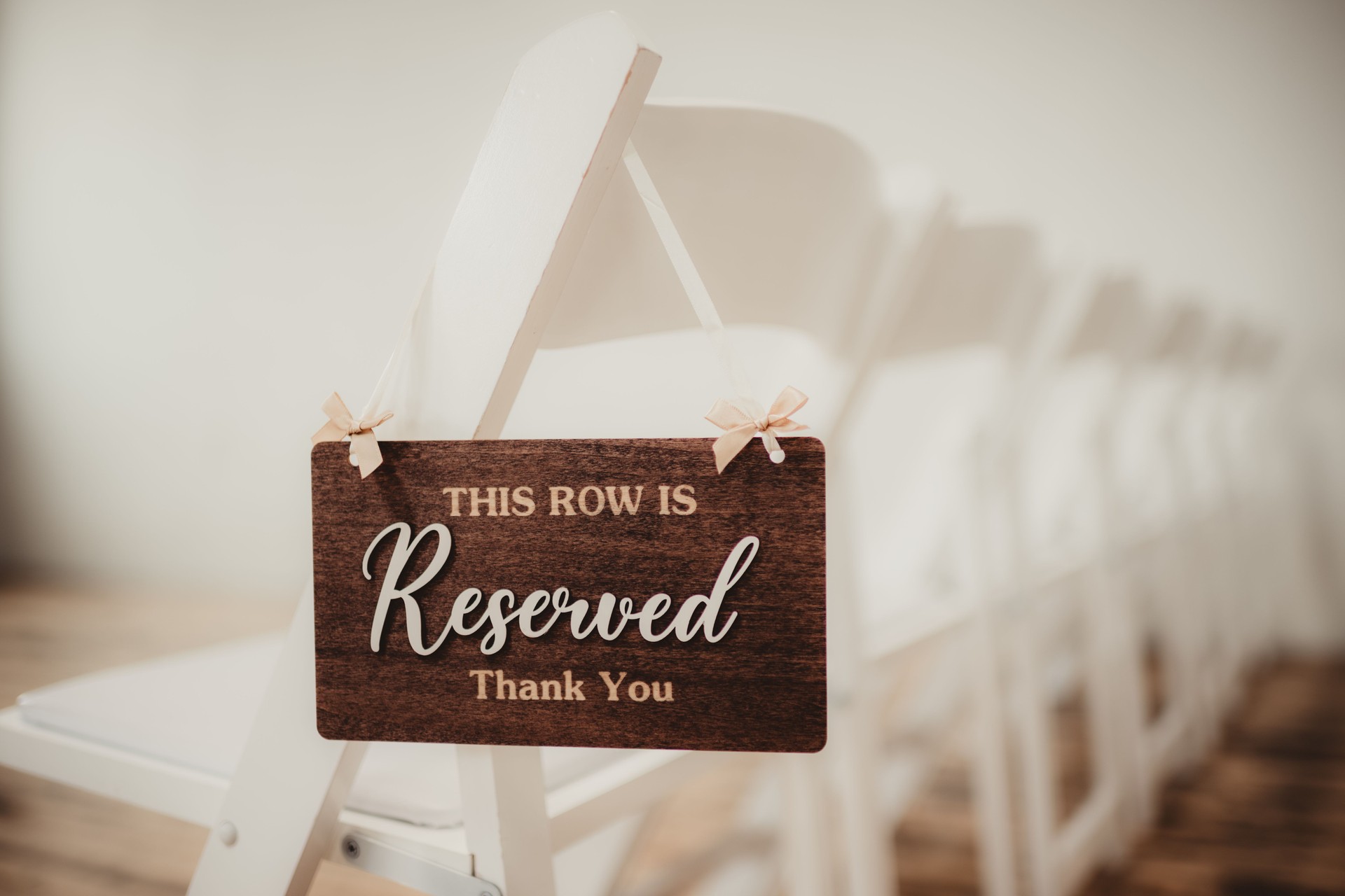 Reserved wedding ceremony sign for guests hanging on chairs